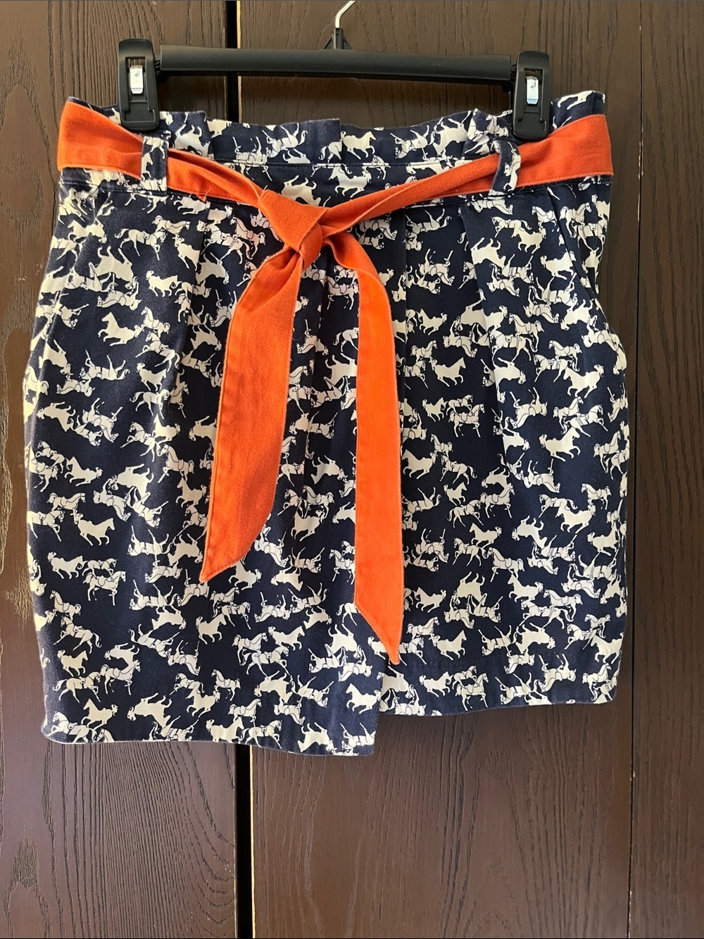 H&M mini navy skirt with cream horses with an orange belt. Size 8